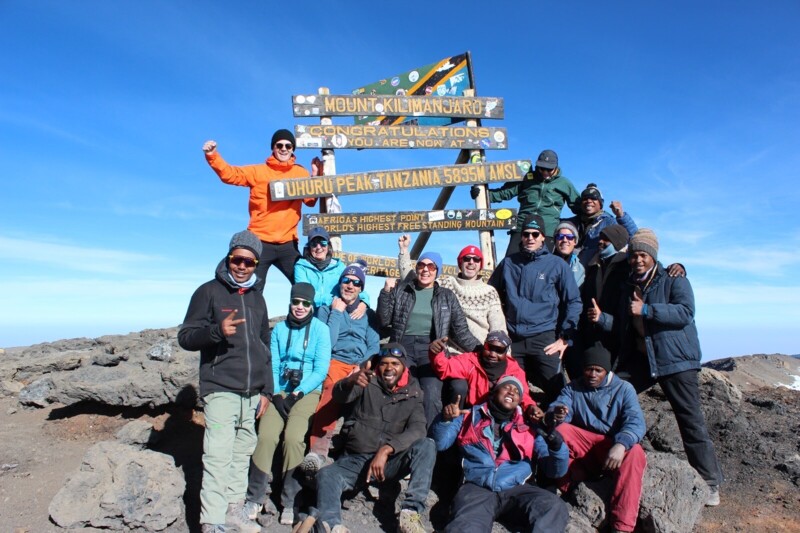 Gruppen vid skylten p&aring; Uhuru Peak, Kilimanjaros topp p&aring; 5 895 meter